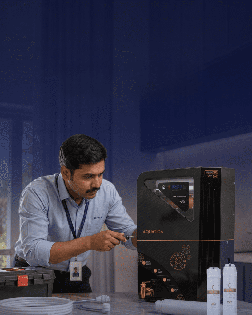 Nexus RO water purifier technician servicing a wall-mounted purifier in an Indian kitchen